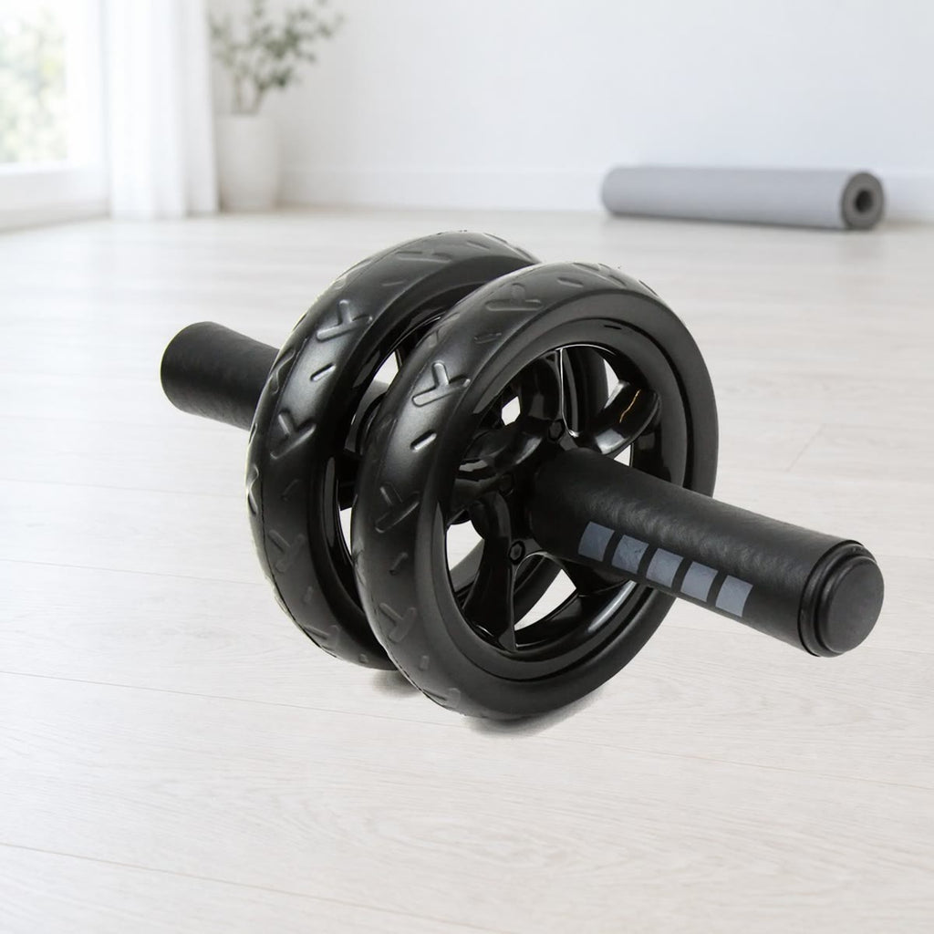 Ab wheel med to svarte, mønstrede hjul og skumhåndtak med grå striper, på et lyst tregulv