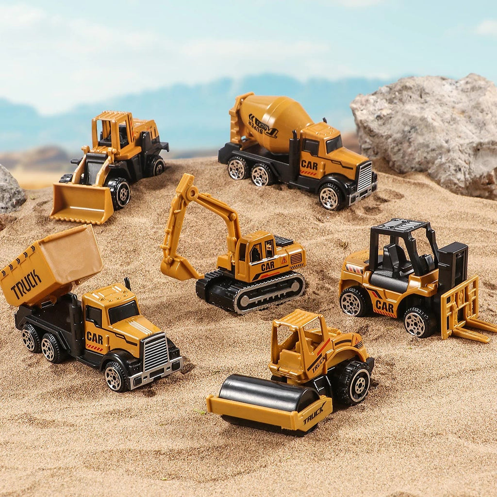 Gravemaskin, hjullaster, betongbil, tippbil, gaffeltruck og veivals spredt utover sanden foran en stor stein