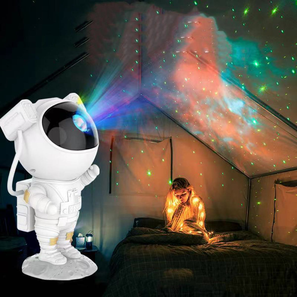 Astronaut-projektoren tent på et barnerom, med stjerner og fargede skyer i taket og et barn i sengen