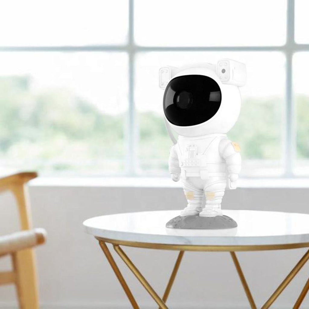 Astronaut-projektoren på et lite bord foran et stort vindu