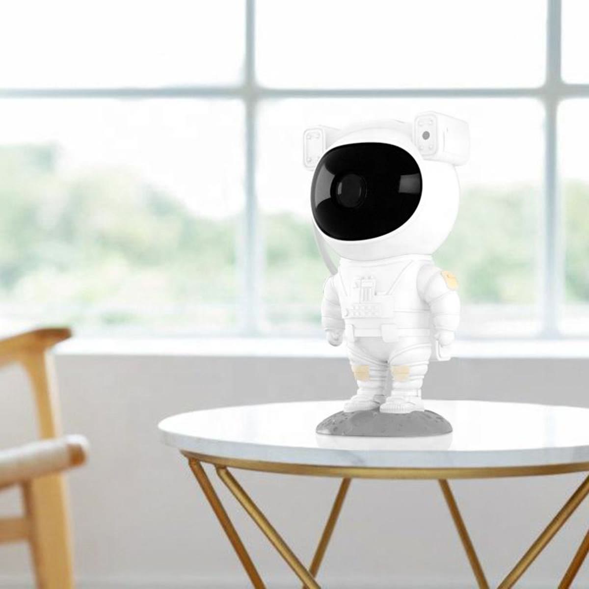 Astronaut-projektoren på et lite bord foran et stort vindu