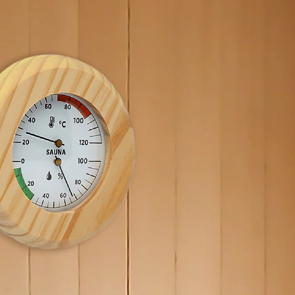 Badstutermometer med hygrometer i fururamme på en lys panelvegg i badstuen