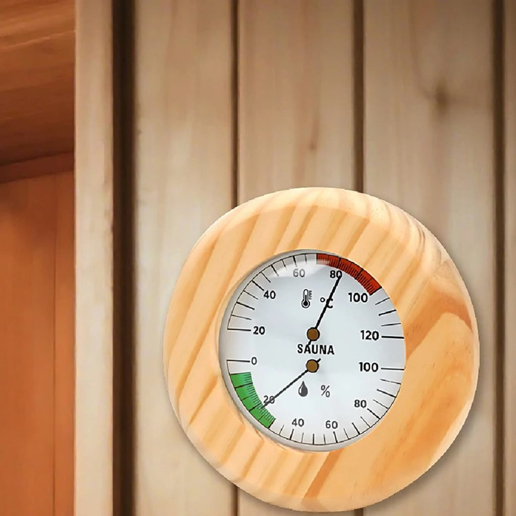 Rundt badstutermometer i furu med skala for temperatur og luftfuktighet på badstuveggen
