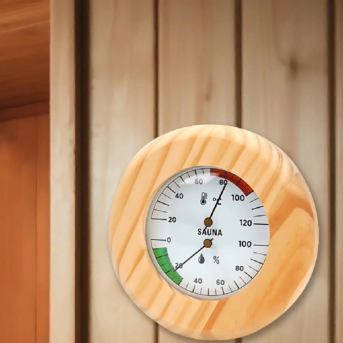 Rundt badstutermometer i furu med skala for temperatur og luftfuktighet på badstuveggen