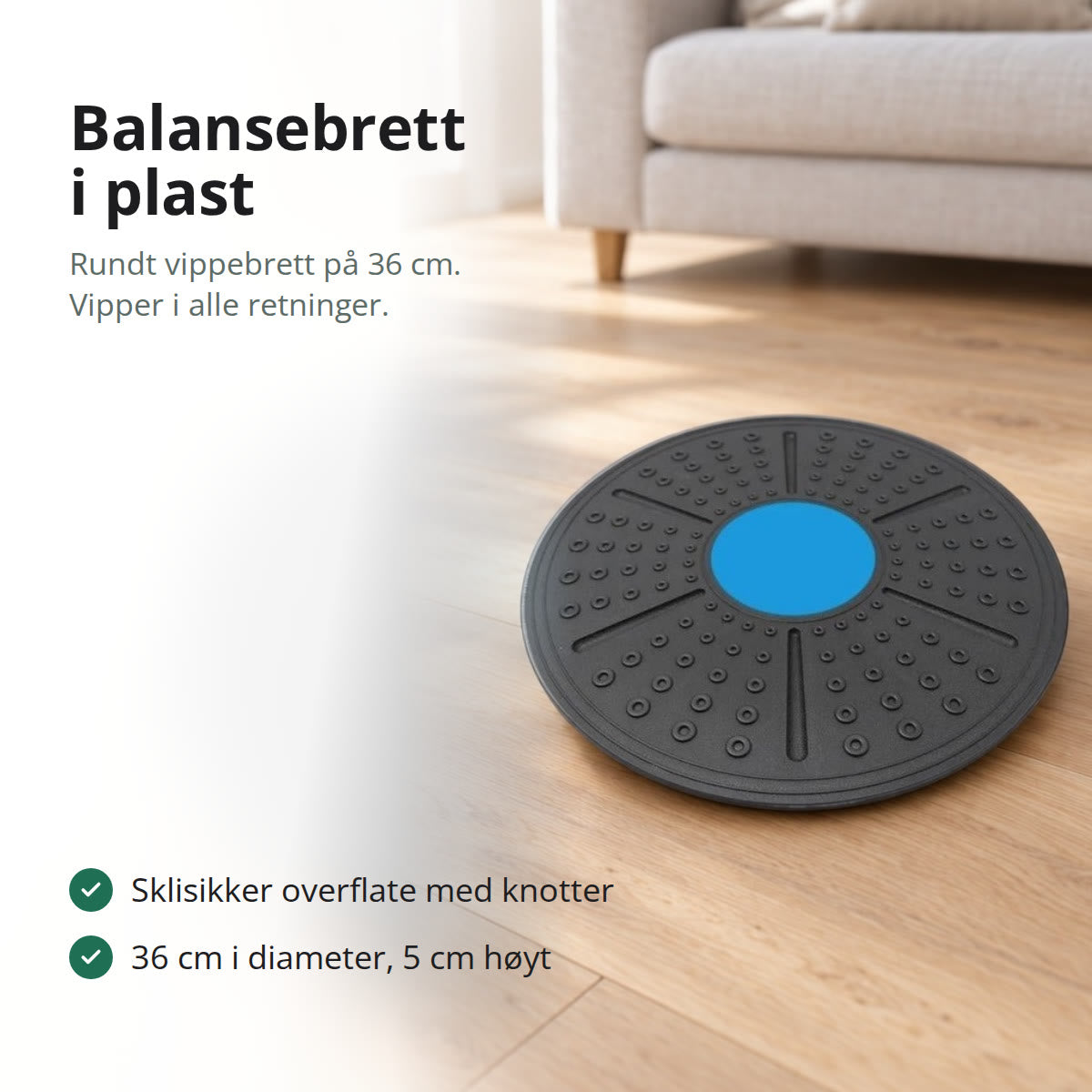 Rundt balansebrett i svart plast med blått midtfelt, liggende på et lyst eikegulv i en stue