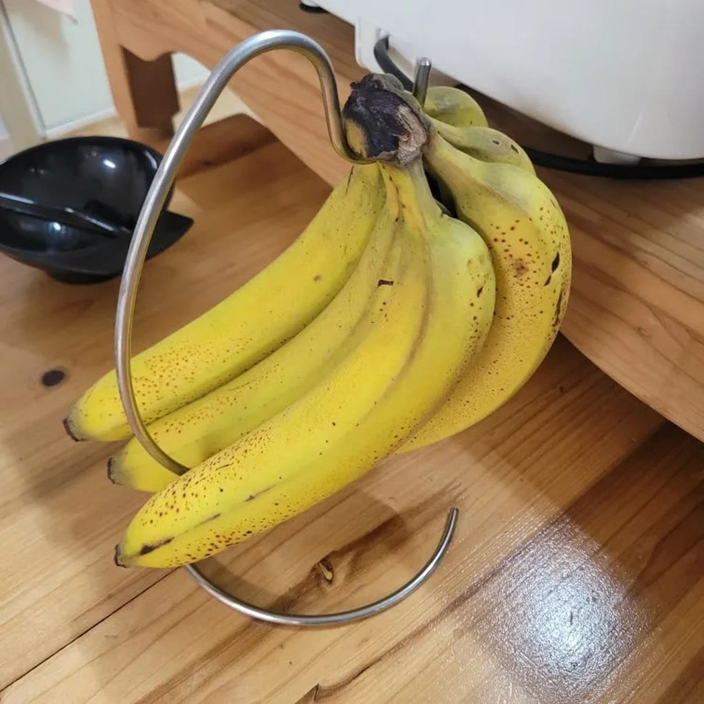 Kjøperbilde: en større klase bananer på stativet, sett ovenfra på et trebord