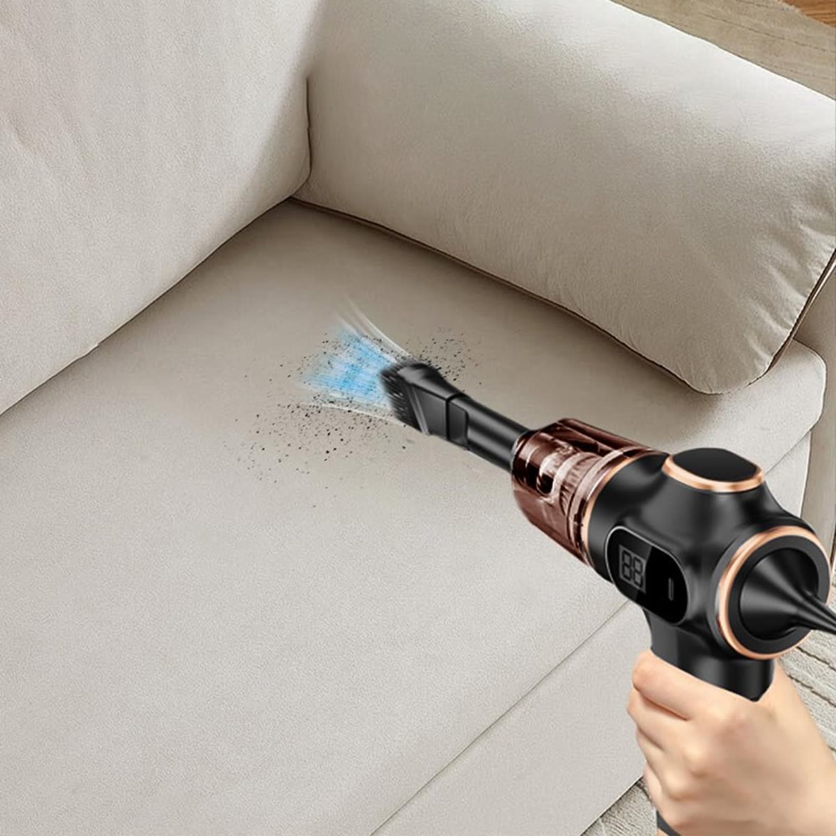 Den sorte bilstøvsugeren brukes i sprekken på en lys sofa