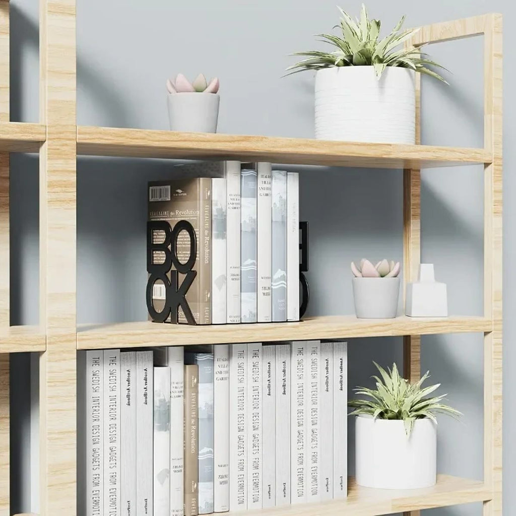 Svart bokstøtte BOOK i en bokhylle i tre med bøker og planter