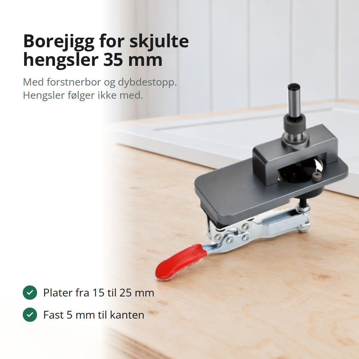 Borejigg i grå aluminium med forstnerbor og rød hurtigspenner på en arbeidsbenk i lys bjørk, med en hvit skapdør bak