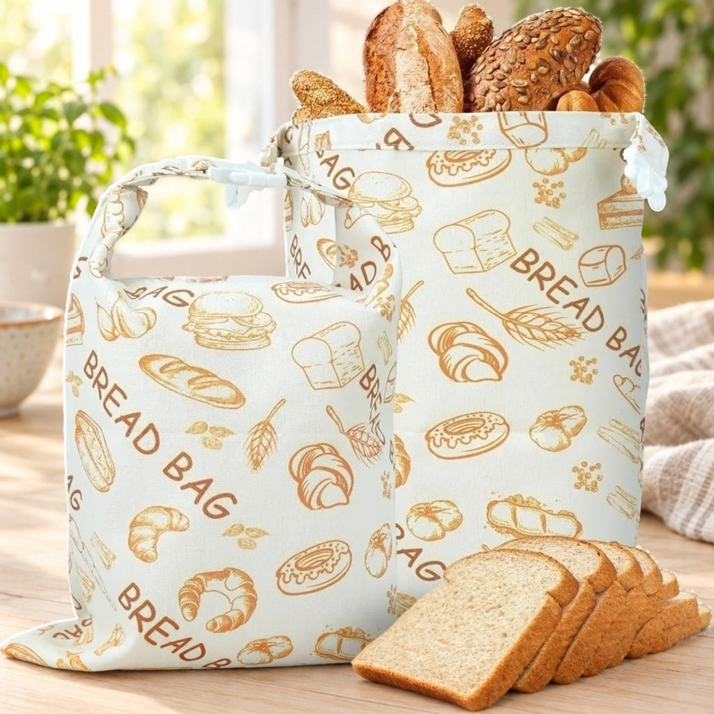 To brødposer med brødmotiv og teksten BREAD BAG, med brød og skiver på et kjøkkenbord