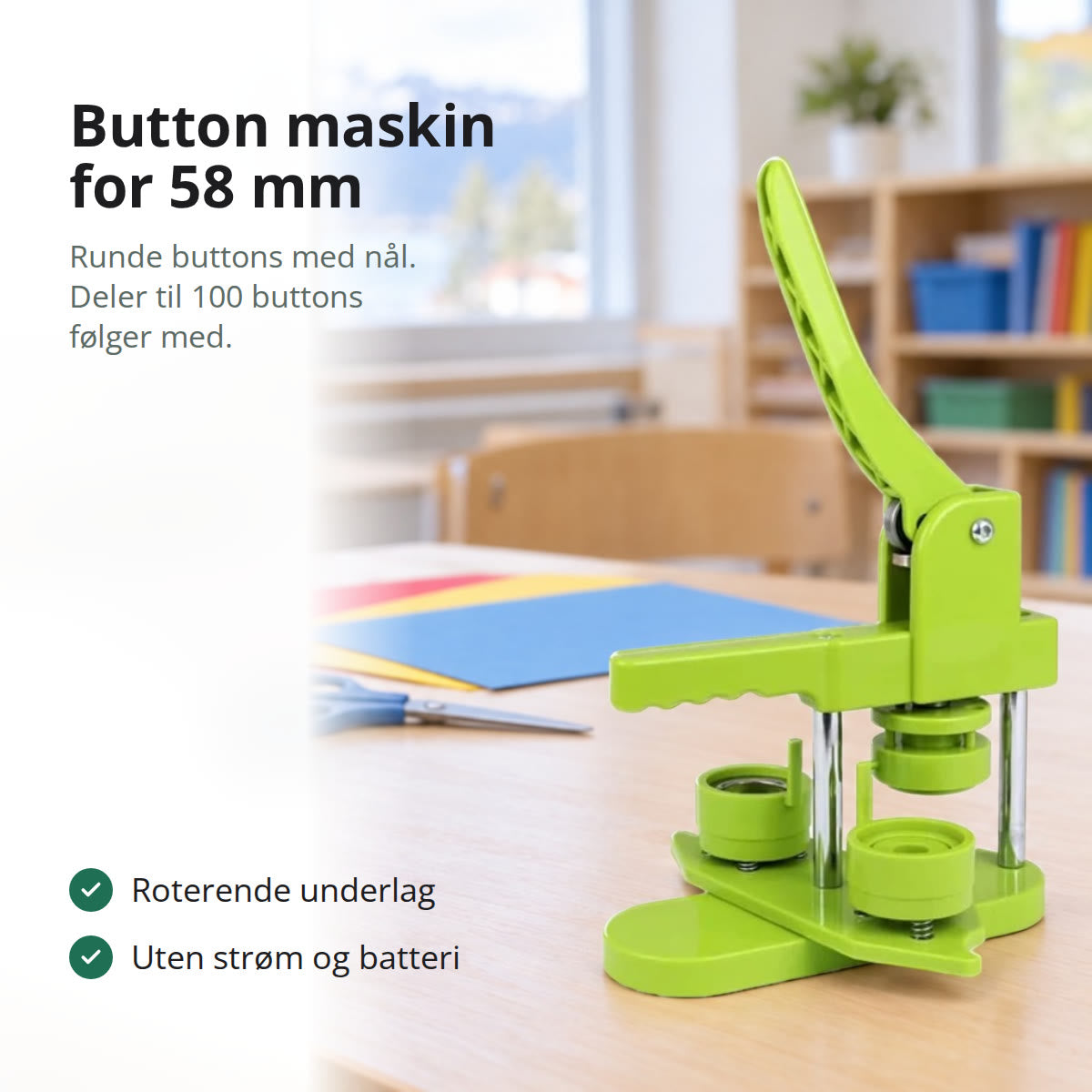 Grønn button maskin med roterende underlag på et bord i lys bjørk i et klasserom, med farget papir og en saks bak