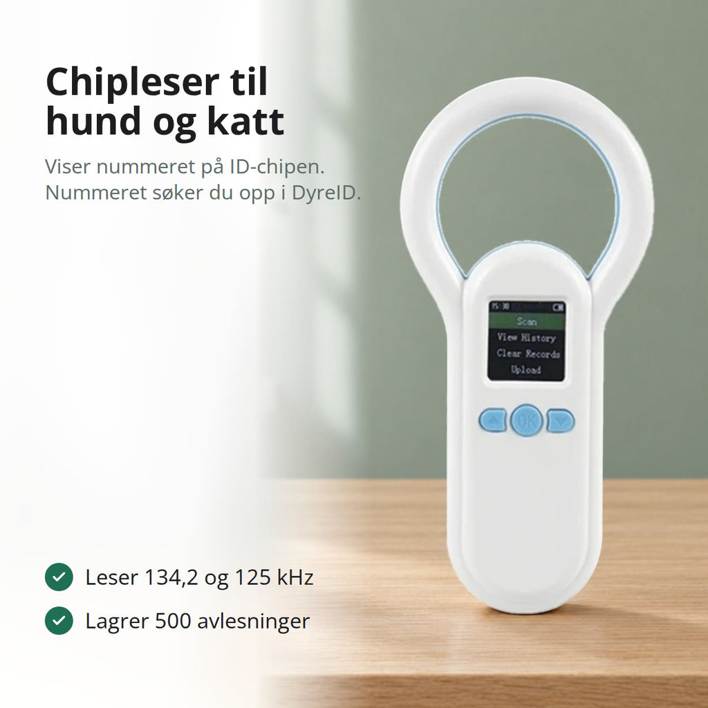 Hvit chipleser til hund og katt med ringformet antenne og fargeskjerm, stående på et eikebord foran en grønn vegg