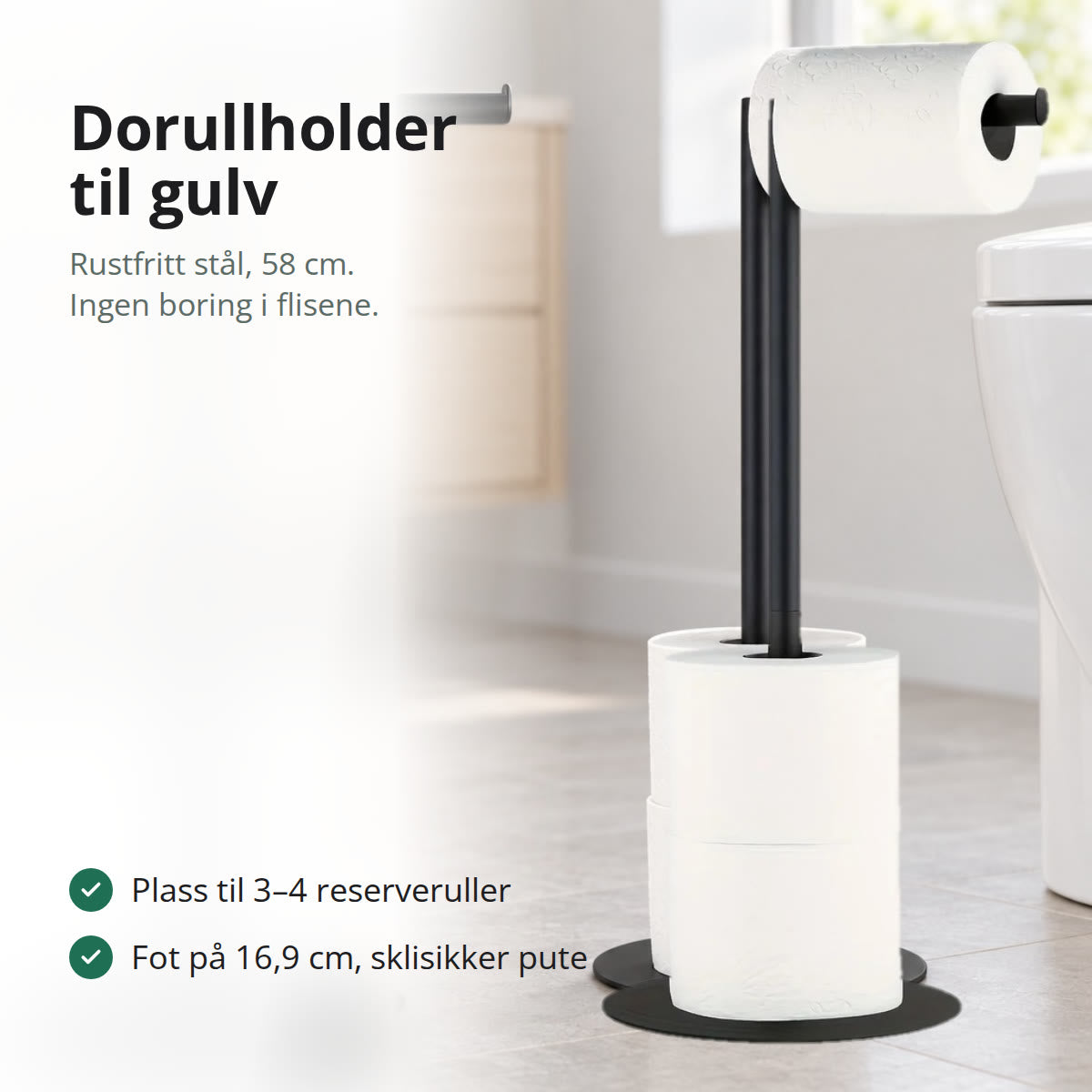 Svart frittstående dorullholder i stål på et lyst baderomsgulv, med rull på toppen og reserveruller på stangen