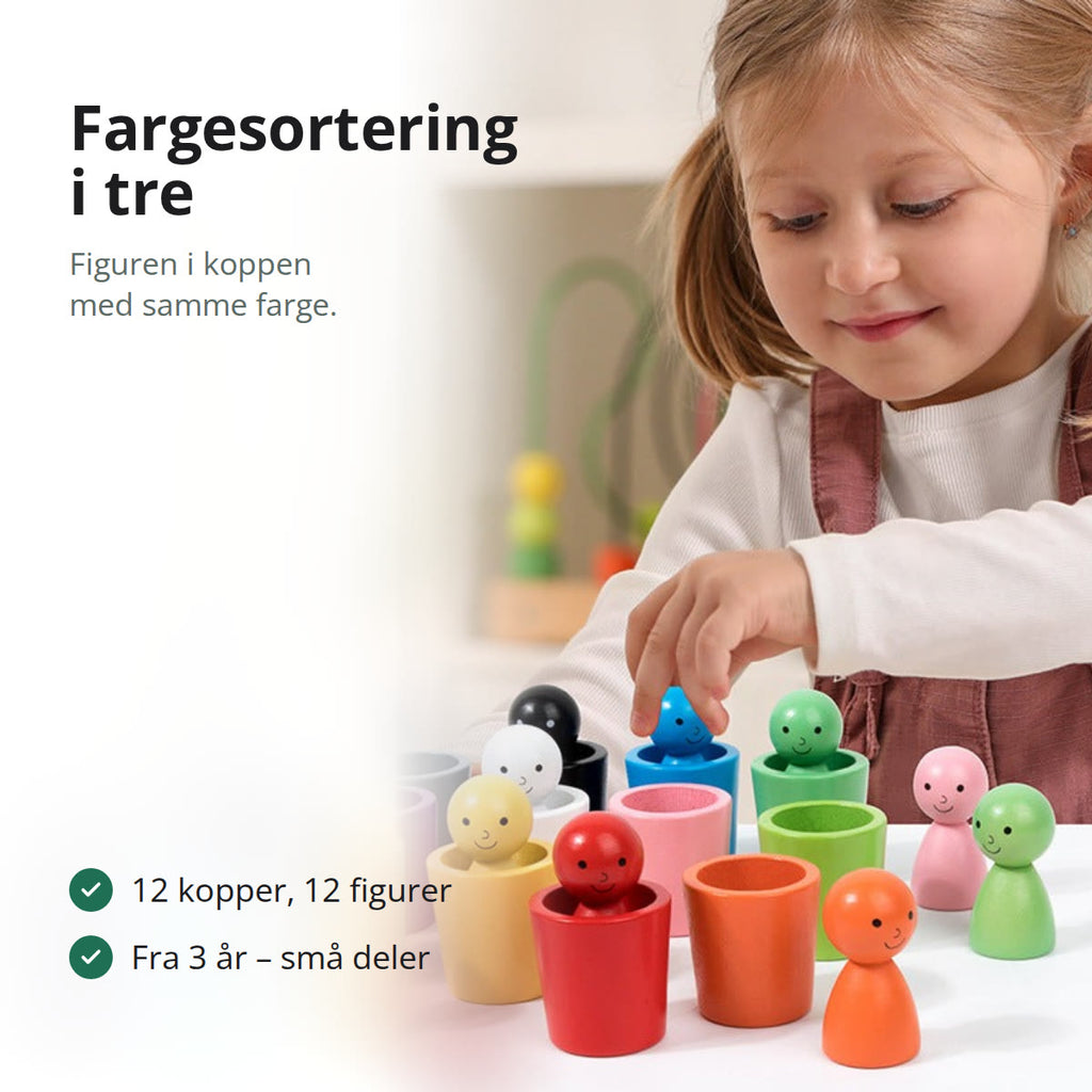 Jente som sorterer små trefigurer i kopper med samme farge på et bord