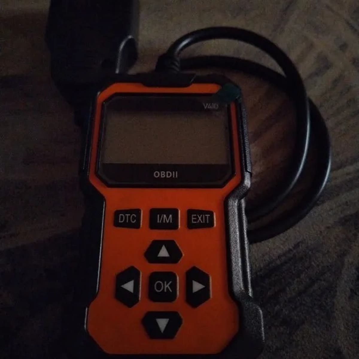 Kjøperbilde av den oransje feilkodeleseren med svart kant, fast kabel og OBD2-plugg