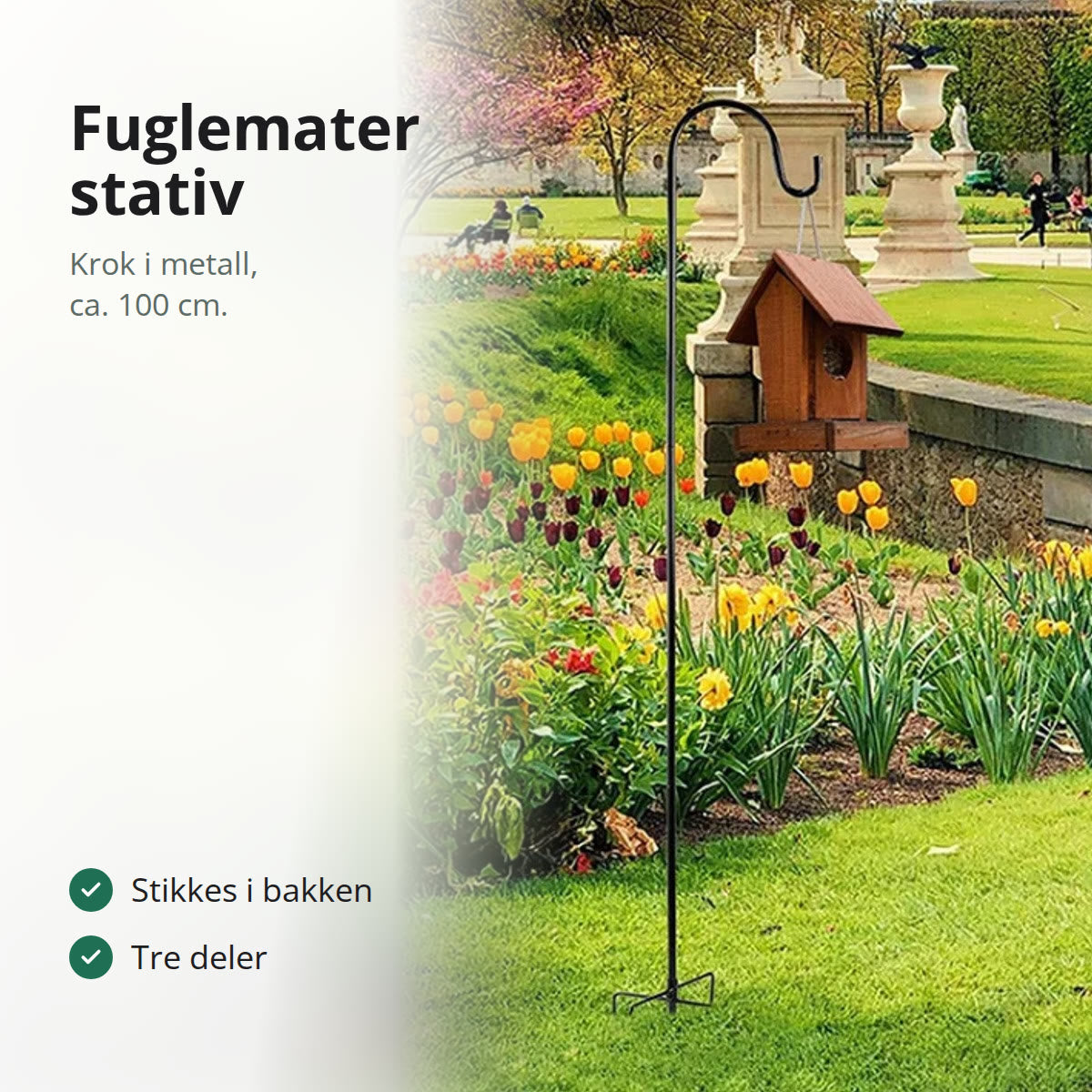 Svart krok i et blomsterbed med et fuglehus hengende i kroken