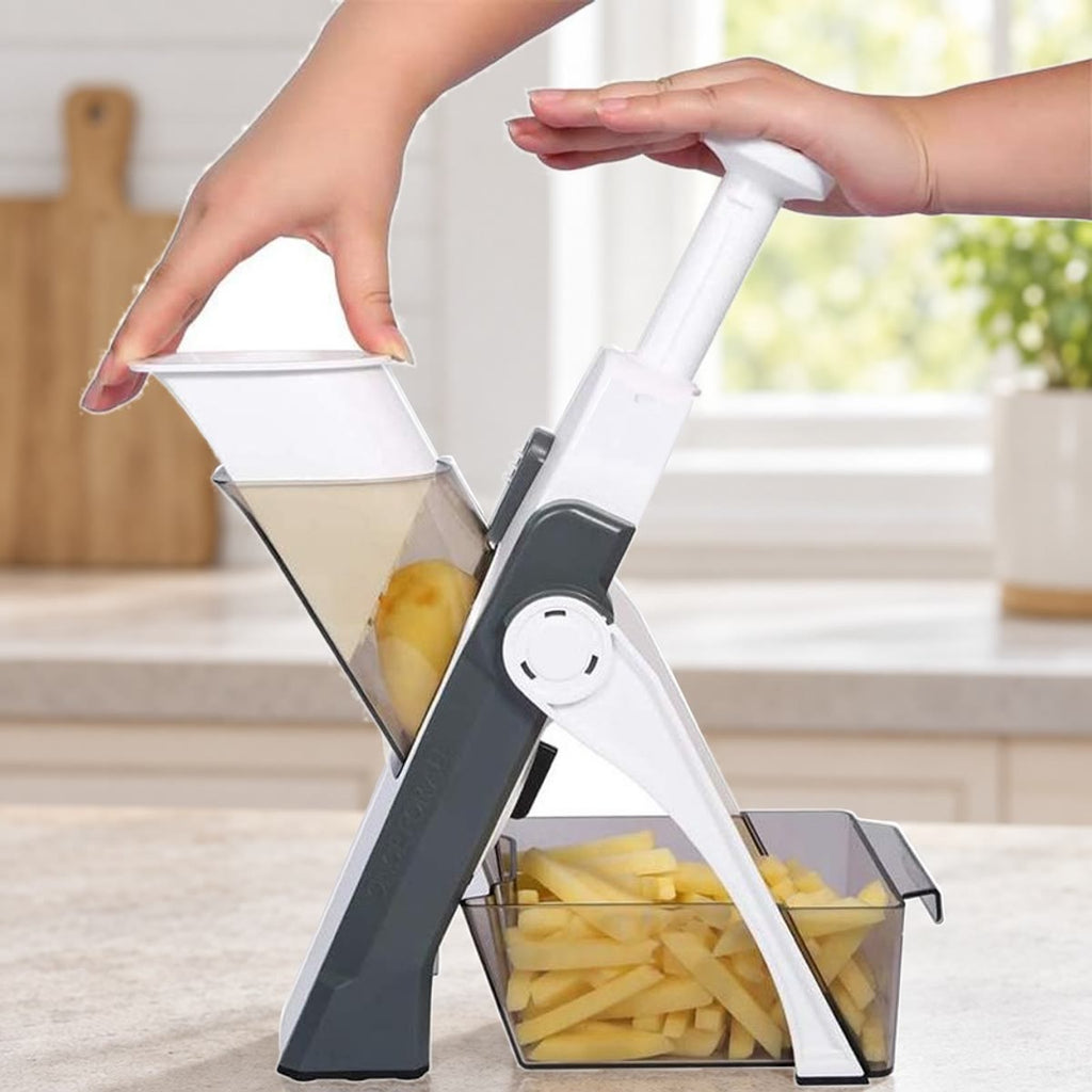 Grå grønnsakskutter på en kjøkkenbenk med pommes frites i oppsamlingsboksen