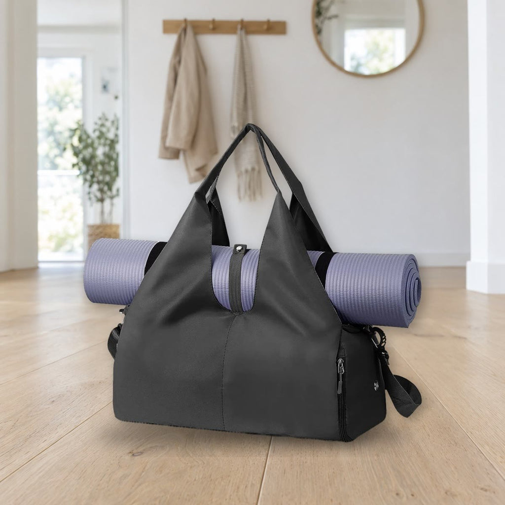 Svart gymbag med en lilla yogamatte festet i stroppene på toppen; matten følger ikke med