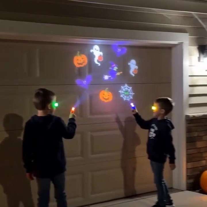 To barn lyser Halloween-motiver på en garasjeport om kvelden
