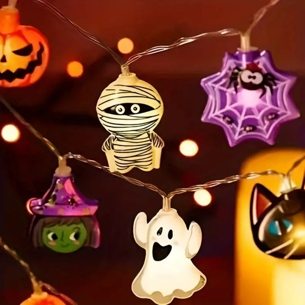 Nærbilde av tente figurer på halloween lyslenken: mumie, edderkoppnett, heks, spøkelse og svart katt
