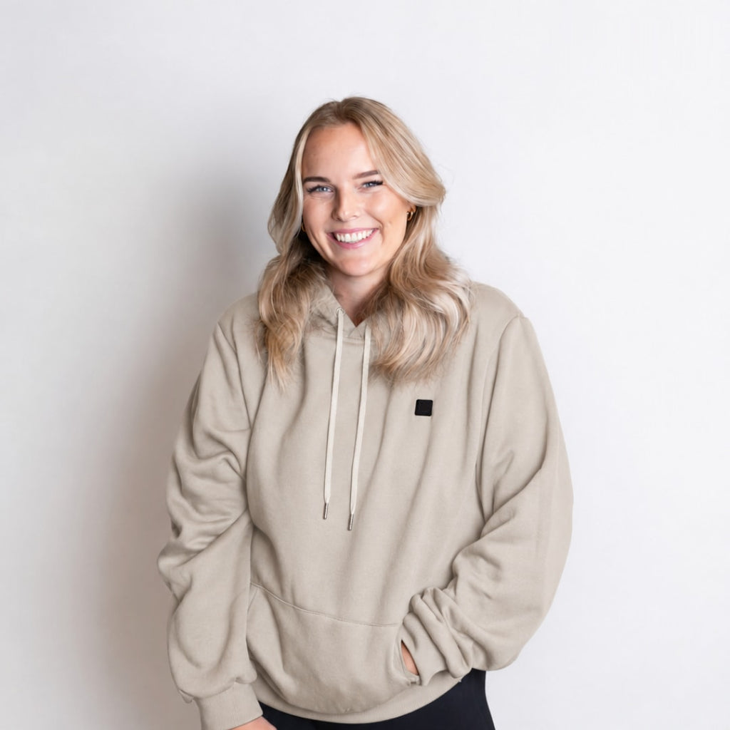 Kvinne i beige Varmro-hettegenser