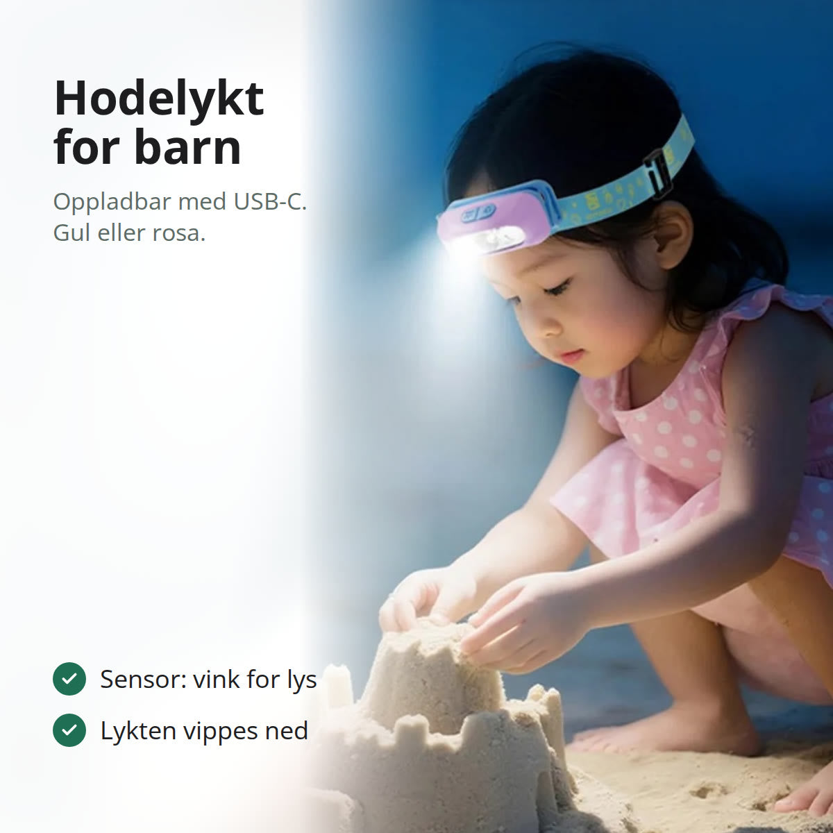 Jente med rosa hodelykt for barn som bygger sandslott i mørket