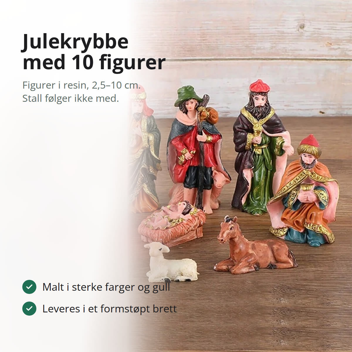 Julekrybbe med ti figurer i sterke farger oppstilt på et trebord