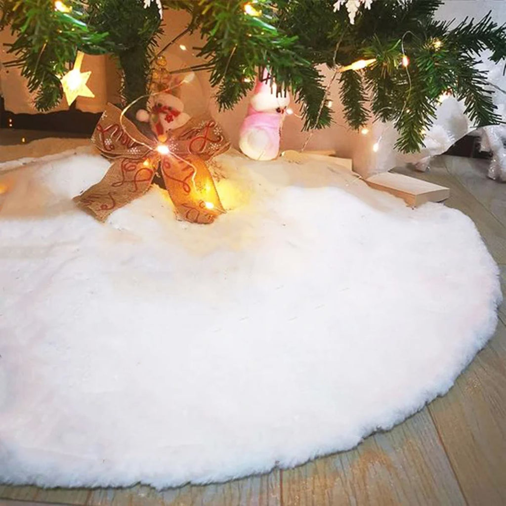 Nærbilde av den lange, hvite plysjen i juletreteppet under et juletre med lysslynge