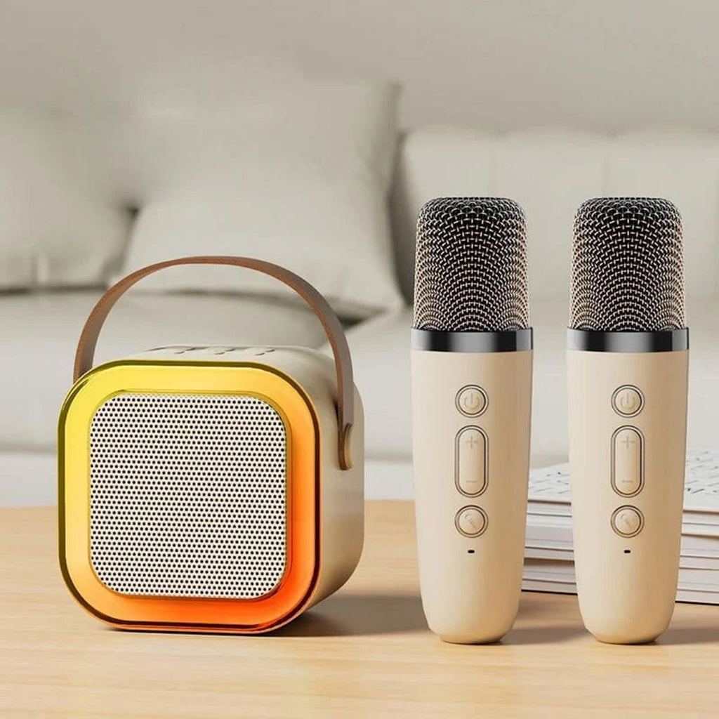 Hvit karaokemaskin med to trådløse mikrofoner på et trebord foran en seng