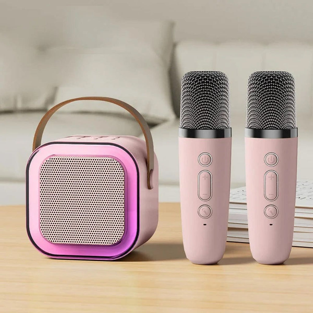 Rosa karaokemaskin med to rosa mikrofoner på et bord