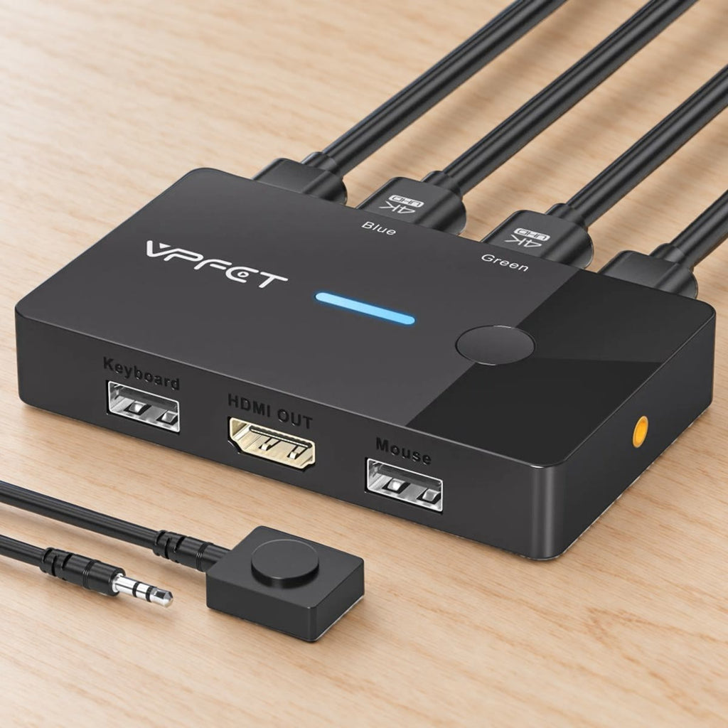 KVM-switchen med bordknapp og jack-plugg på et skrivebord i lys bjørk, med HDMI- og USB-kabler i baksiden