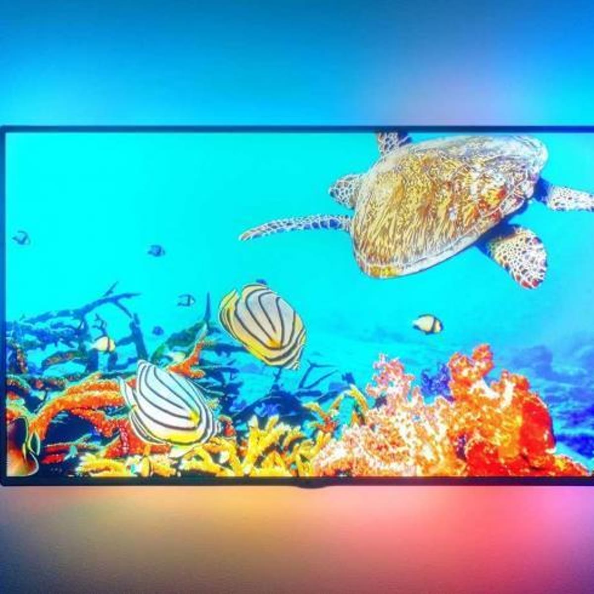 TV med turkis LED-lys bak skjermen på en mørk vegg