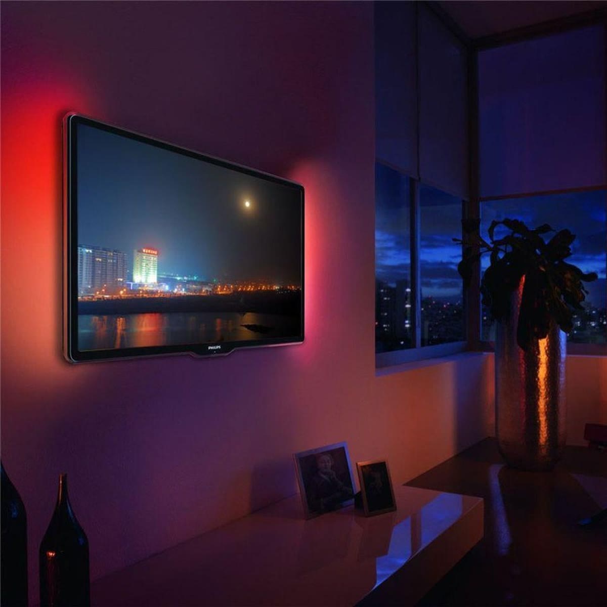 TV med rødt og blått LED-lys bak skjermen i en stue med utsikt