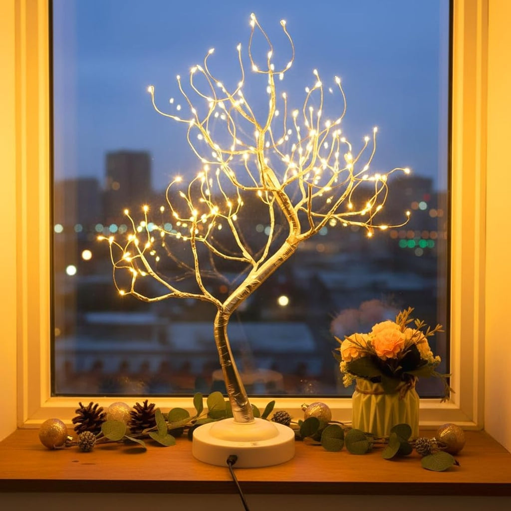 LED-treet i vinduskarmen med julepynt om kvelden