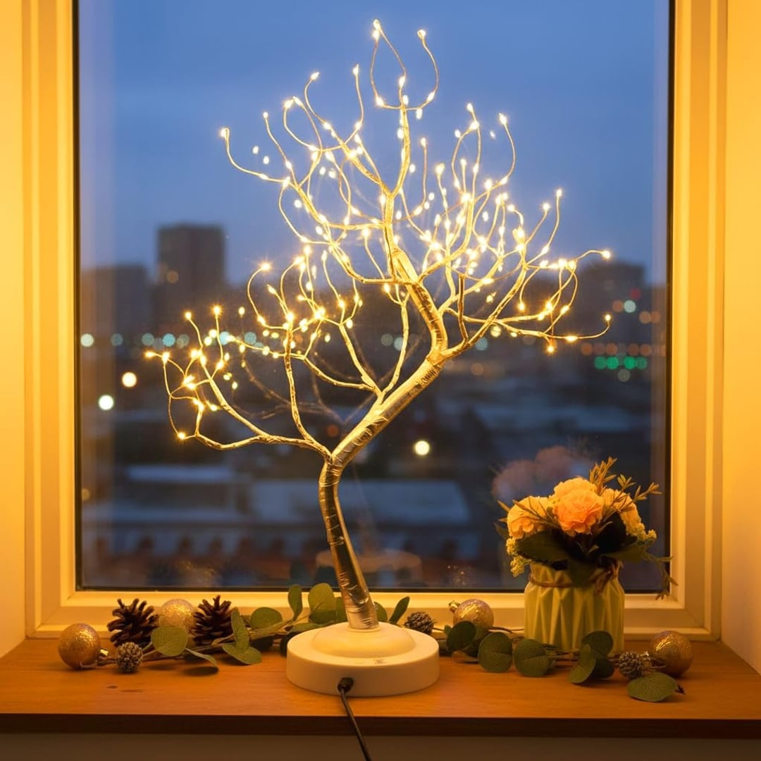 LED-treet i vinduskarmen med julepynt om kvelden