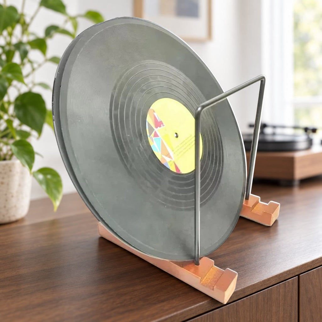 Vinylplate stående i et LP-stativ med føtter i tre og rammer i sort metall på en skjenk i valnøtt