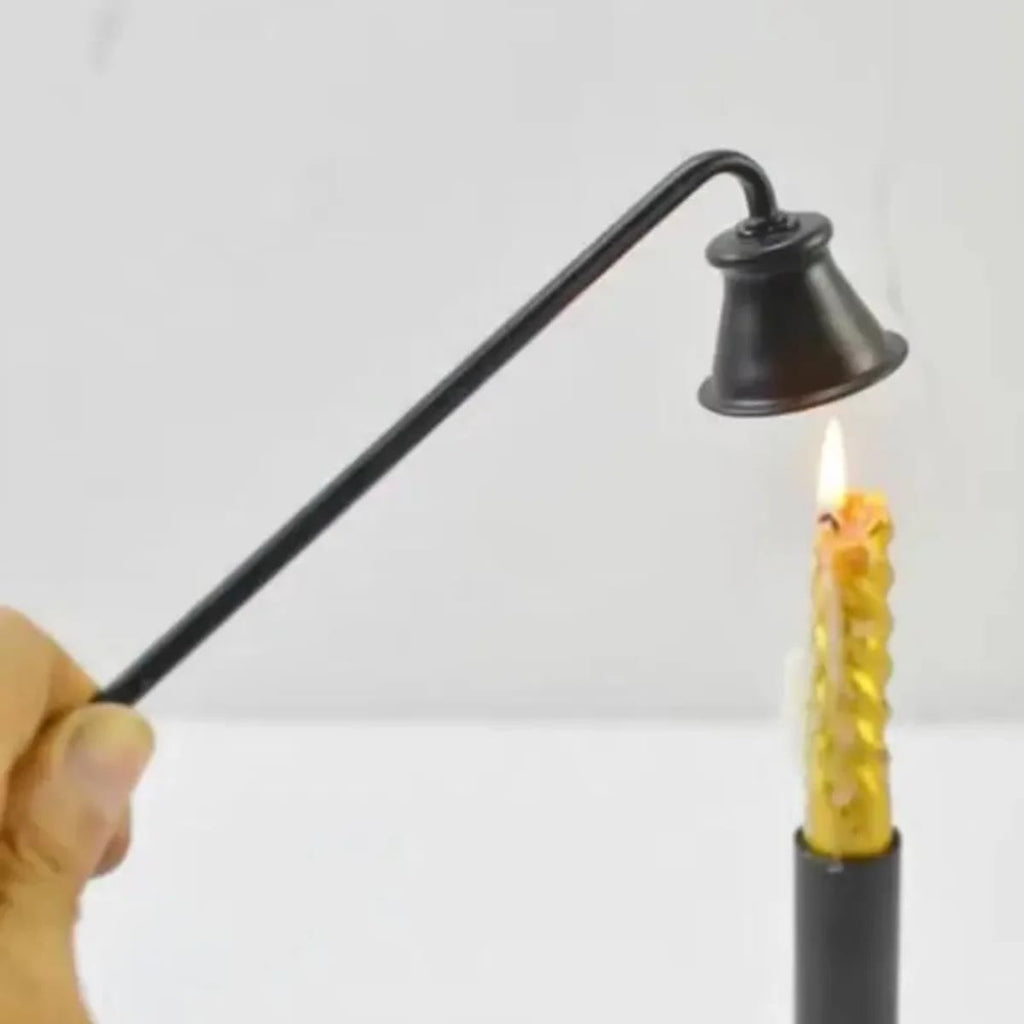 Sort lysslukker som holdes over flammen på et gult kronelys i en sort lysestake