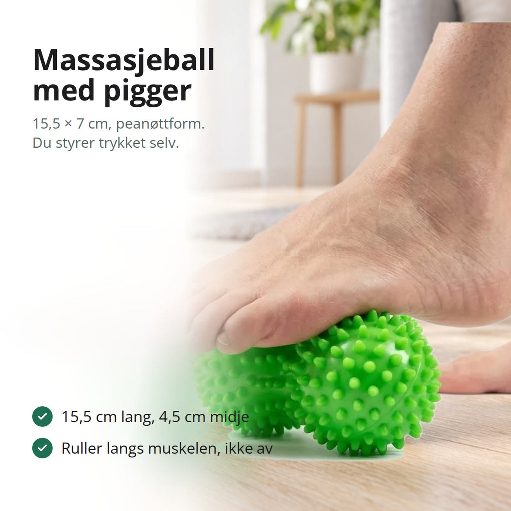 Grønn piggete massasjeball formet som en peanøtt, liggende på et lyst tregulv
