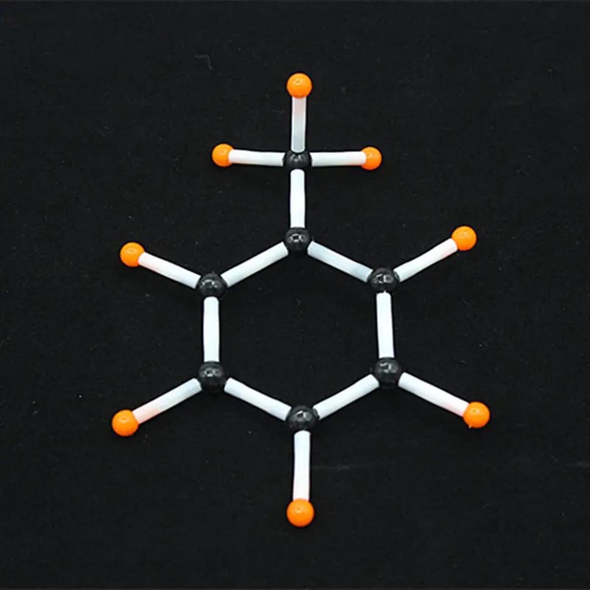 Seksring av svarte karbonatomer med oransje hydrogenatomer og hvite plastrør, bygget med molekylbyggesettet