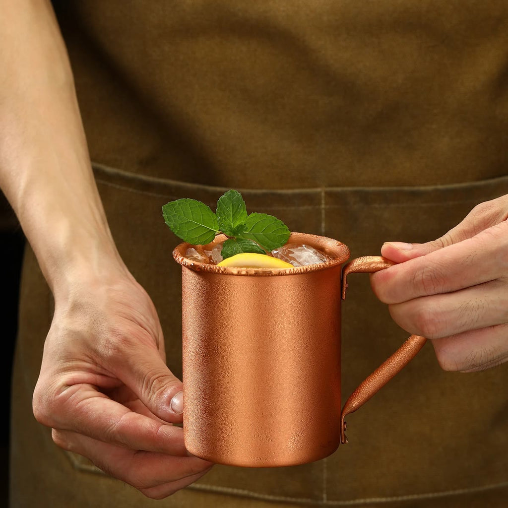 En bartender holder kruset fylt med is, lime og mynte
