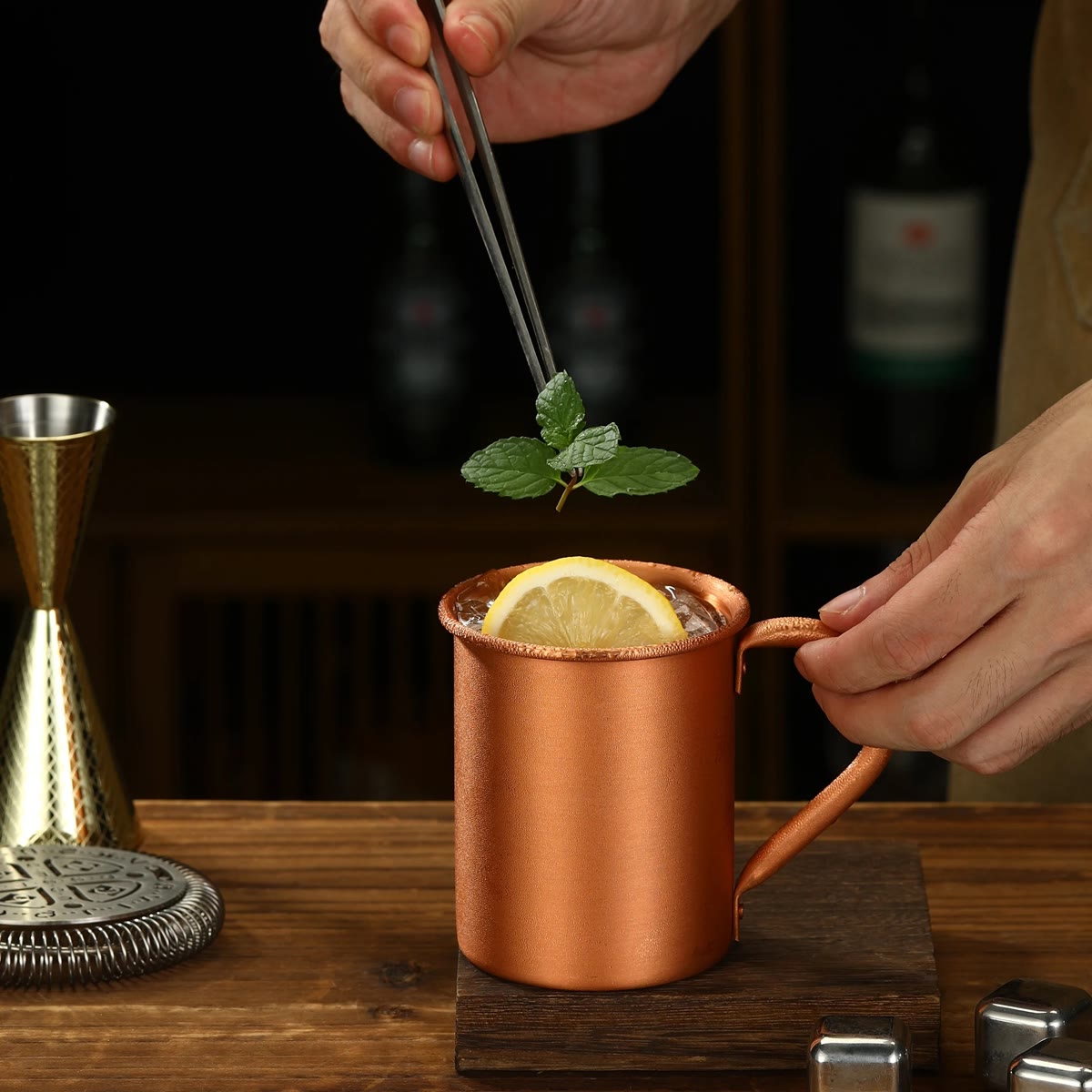 Kruset på en bardisk, en bartender legger mynte på toppen av drinken