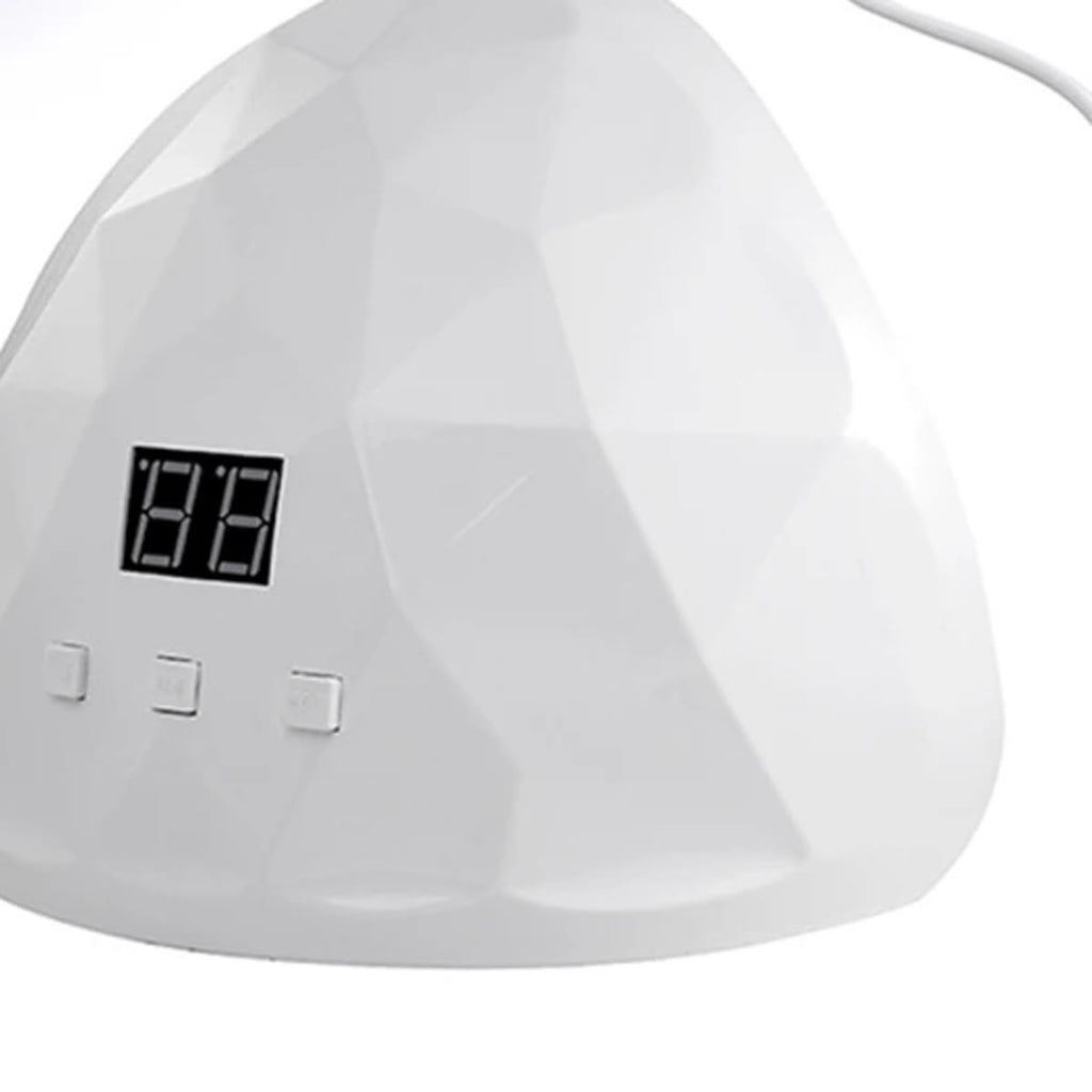 Hvit neglelampe med fasettert overflate, display og tre knapper, sett forfra