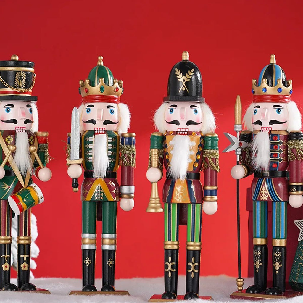 Nøtteknekker figurene foran en rød bakgrunn med kunstsnø og et lite juletre