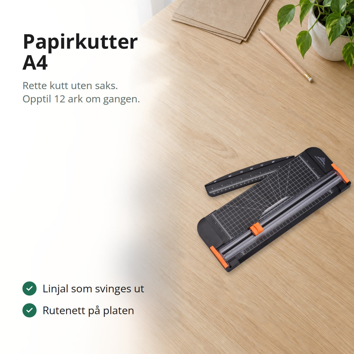 Svart papirkutter med oransje knivhode og linjal, på en lys skrivepult