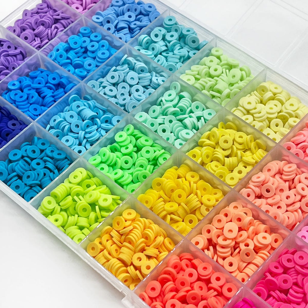 Boksen sett skrått ovenfra med lilla, blå, grønne, gule og rosa leirperler i rommene og lokket bak