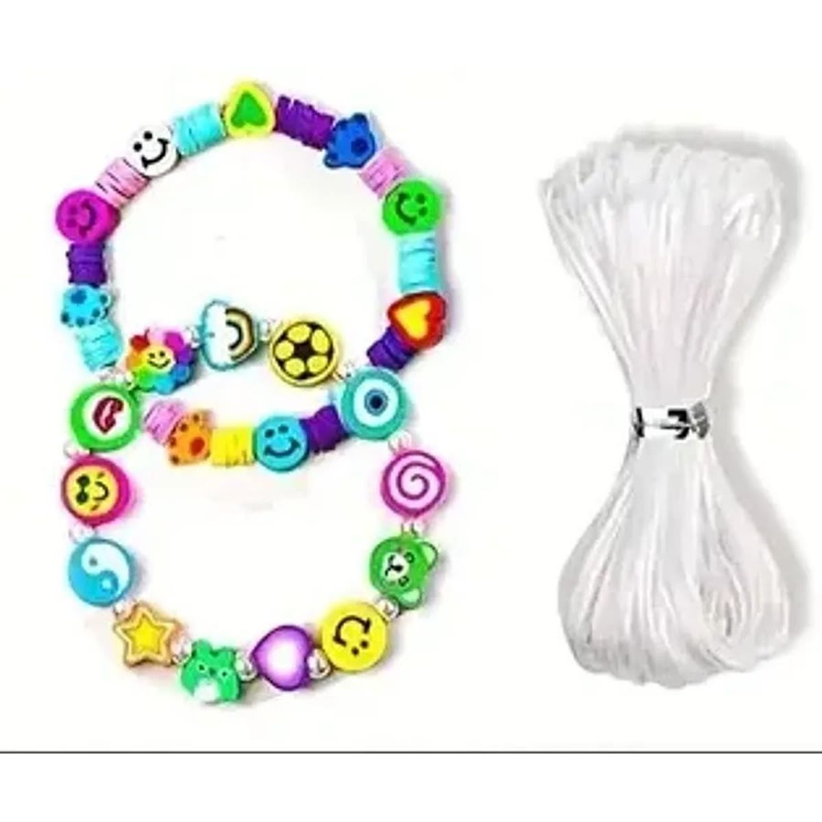 To armbånd laget av leirperler med smilefjes og motiver, ved siden av en rull elastisk tråd