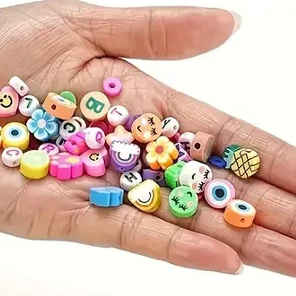 Leirperler med motiv og små leirskiver i en hånd, som viser hvor små perlene er; motivene i settet kan variere
