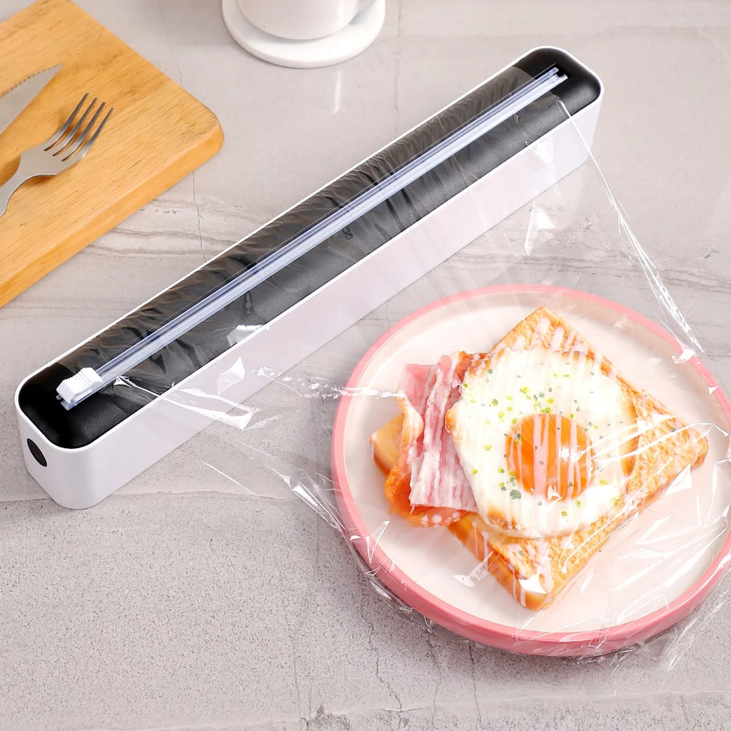 Svart plastfolie dispenser med plastfolie trukket ut over en tallerken med toast og egg
