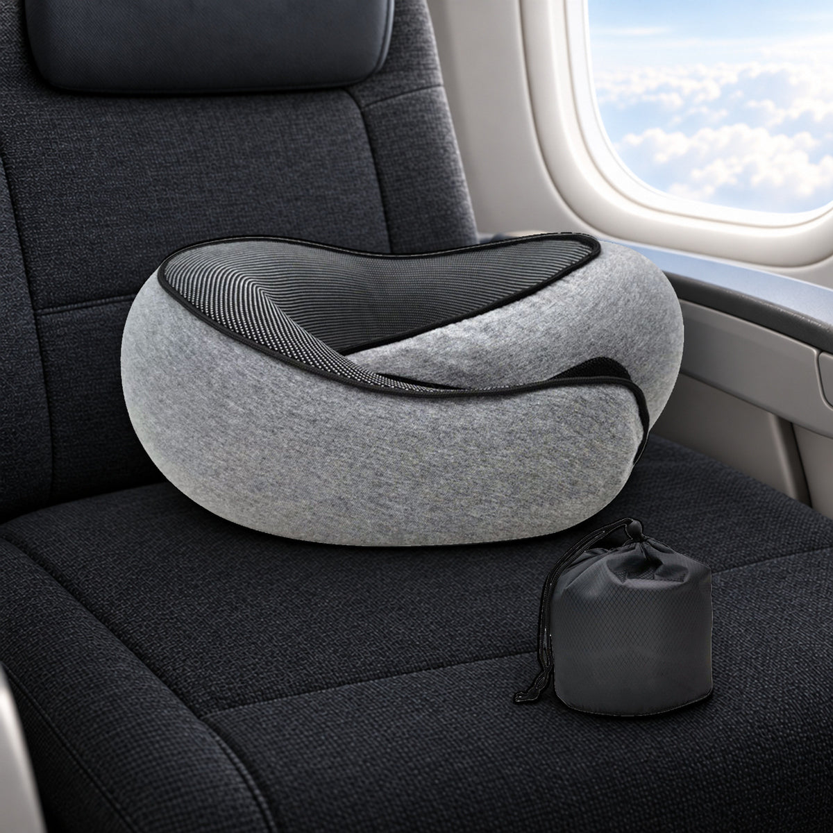 Grå Døsa reisepute i memory foam med oppbevaringspose på et vindussete i et fly