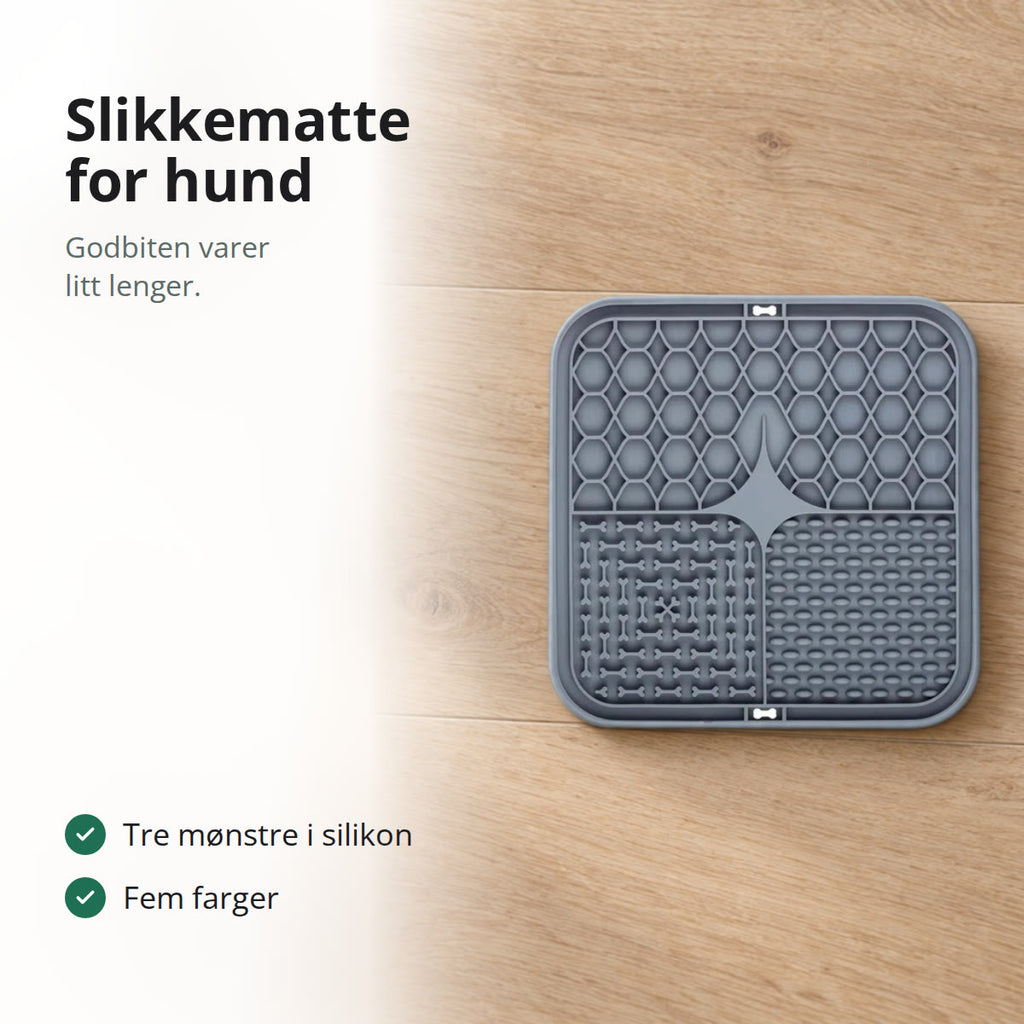 Grå slikkematte for hund på et eikegulv ved en hvit matskål